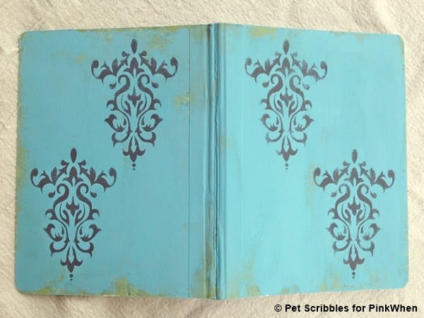 altered composition book with paint and stencils