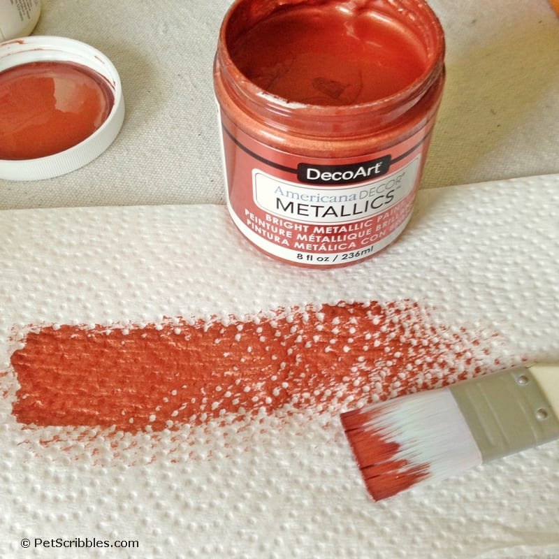 dry brushing metallic paint onto a craft pumpkin