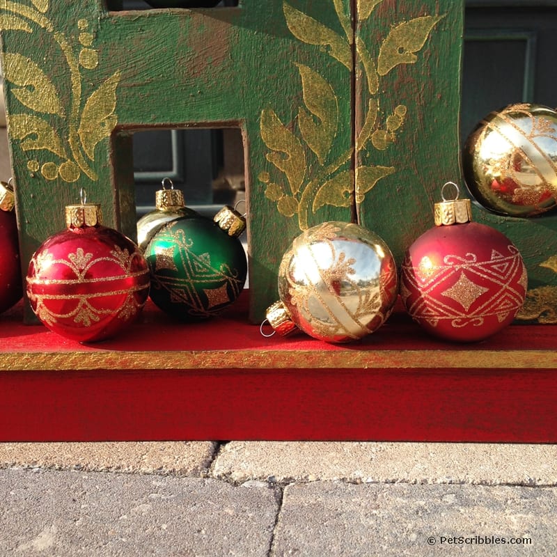 Christmas ornaments glued onto painted sled