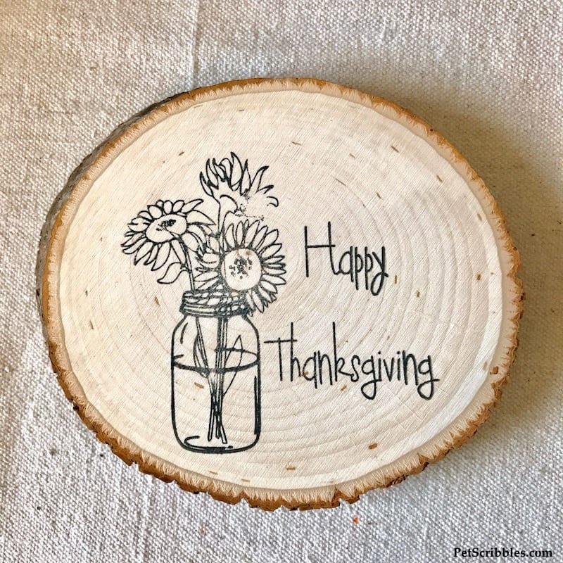 a Happy Thanksgiving stamp design on a wood slice