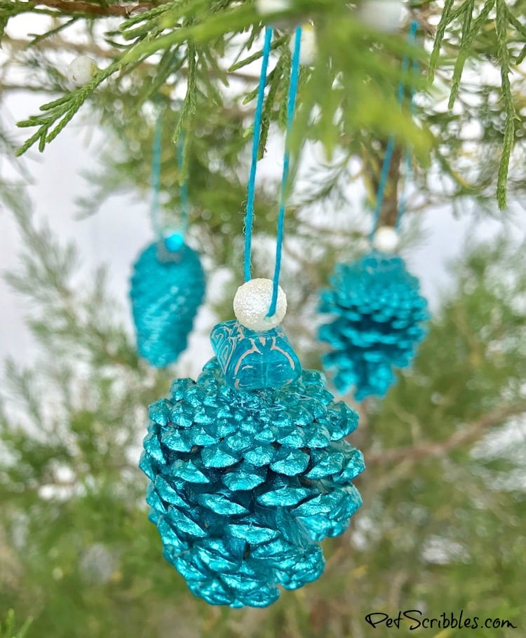 teal pinecone ornaments hanging on a tree