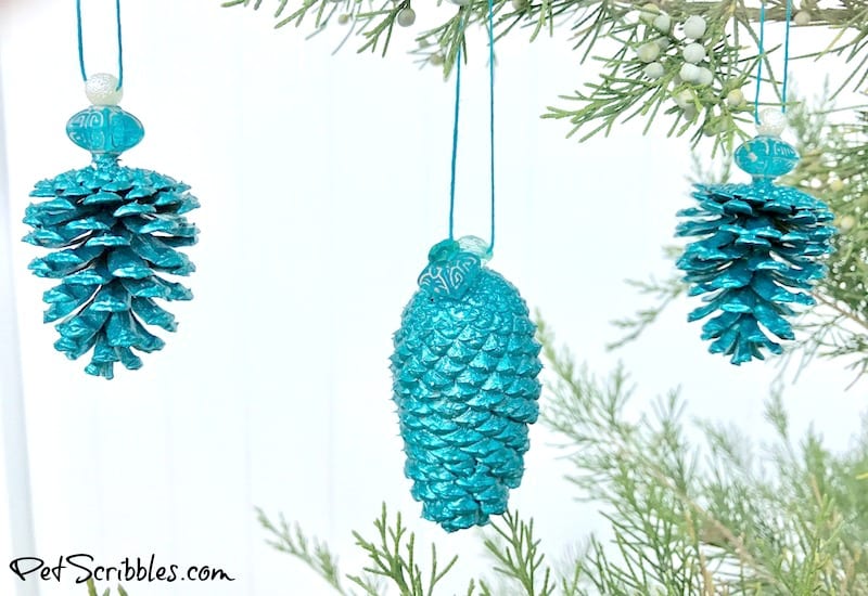 3 different pinecones painted with teal metallic paint