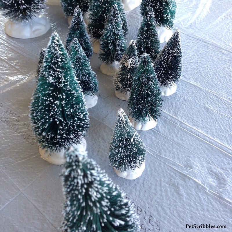green bottle brush trees covered with fake snow