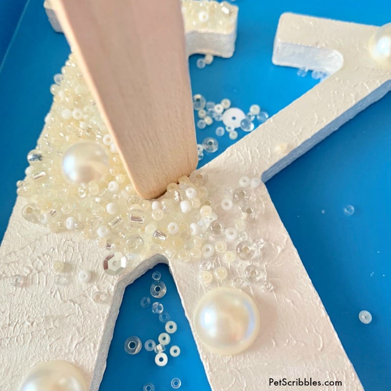 use a craft stick to keep beads in place