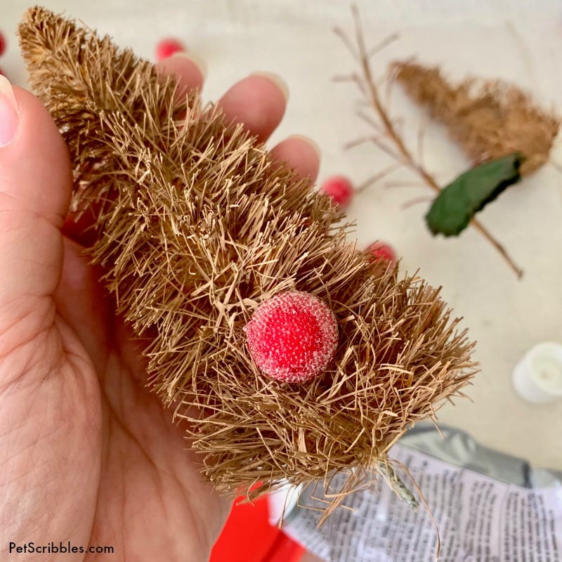 attaching mini ornaments to bottle brush tree