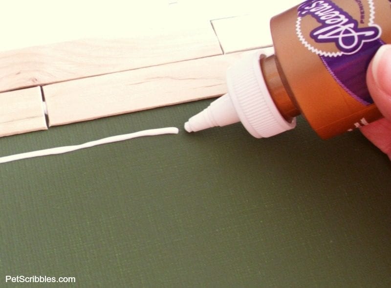 attaching craft sticks to canvas with glue