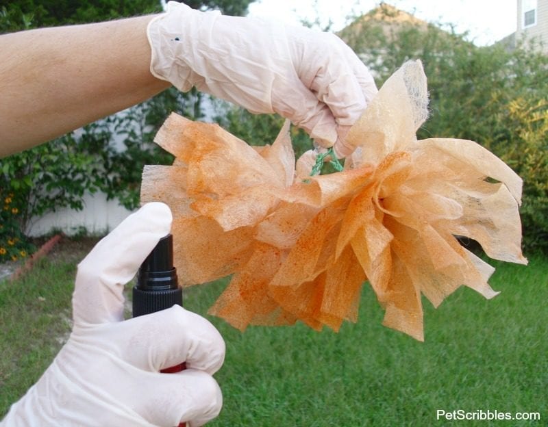 spraying orange glimmer mist on dryer sheets