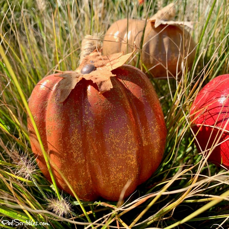 orange glittered pumpkin in ornamental grass