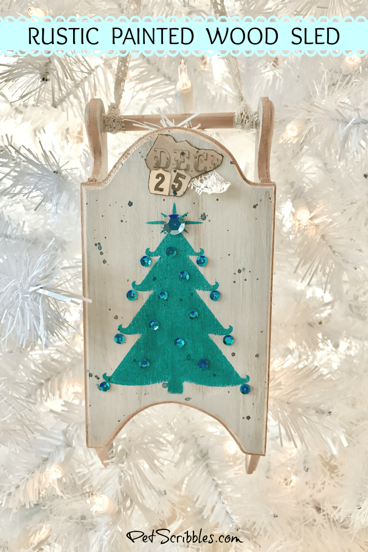 hanging rustic wood sled on white Christmas tree