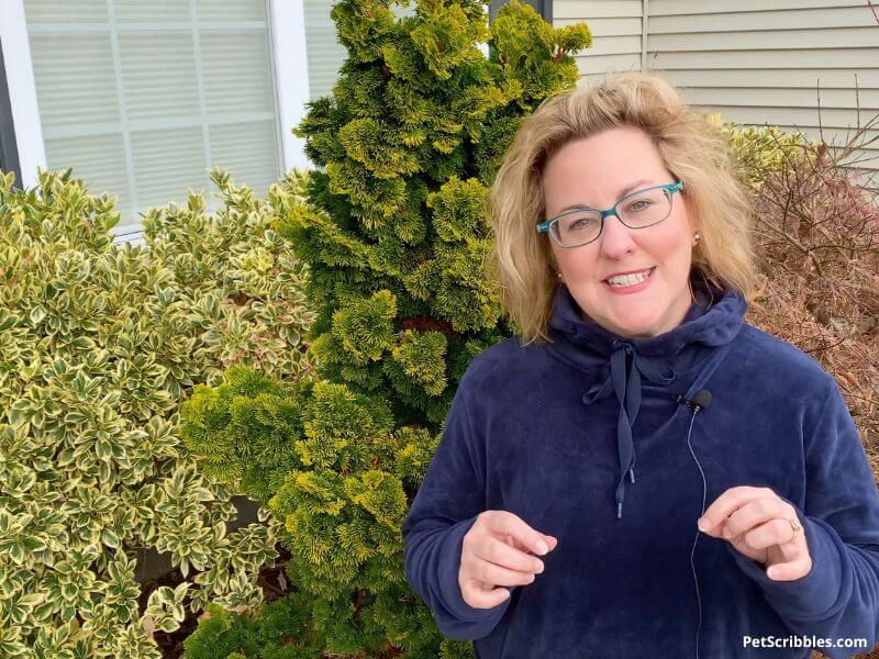 woman in front of garden shrubs